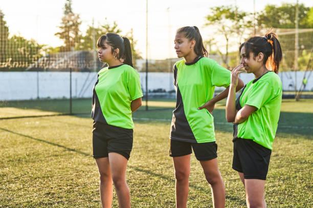 istock Soccer girls looking away while standing on field 1193487416