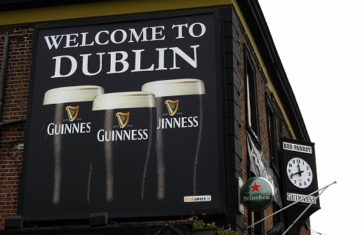 9th December 2019, Dublin, Ireland. The Red parrot pub on Dorset Street Lower with a Guinness 'Welcome to Dublin' poster.