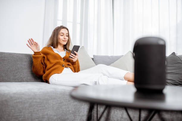 istock Woman controlling home devices with a voice commands 1193488786