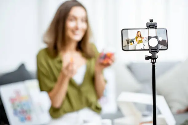 Young woman recording her vlog about healthy eating and nutritional supplements, close-up on a phone screen. Preventive medicine and influencer marketing concept