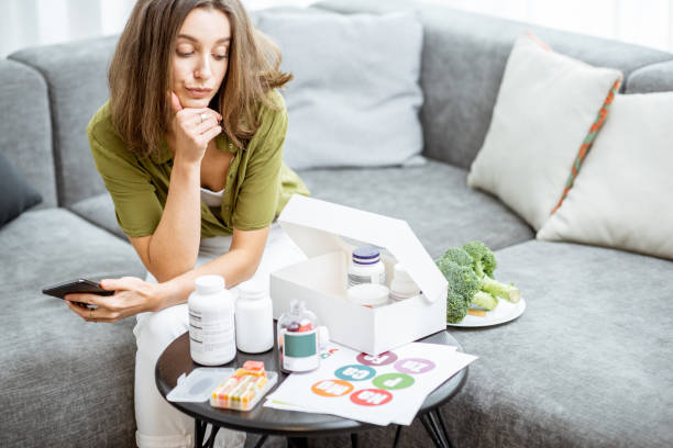 istock Thoughtful woman with vitamins or nutritional supplements at home 1193488918