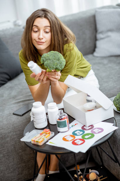 istock Thoughtful woman with nutritional supplements and broccoli at home 1193488923
