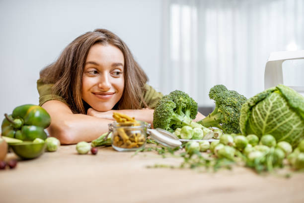 giovane donna con ingredienti alimentari vegani freschi - cavolo broccolo foto e immagini stock