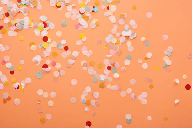 istock decorative and colorful confetti on orange background 1193489555