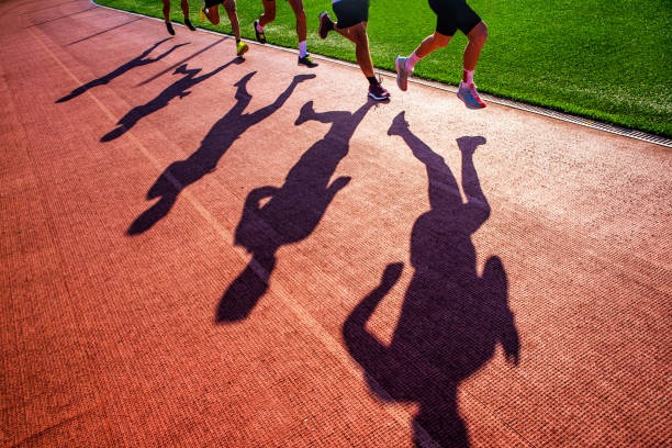 foto de atletismo deportivo de pista y campo. sombra de corredores en pista. - triathlete fotografías e imágenes de stock