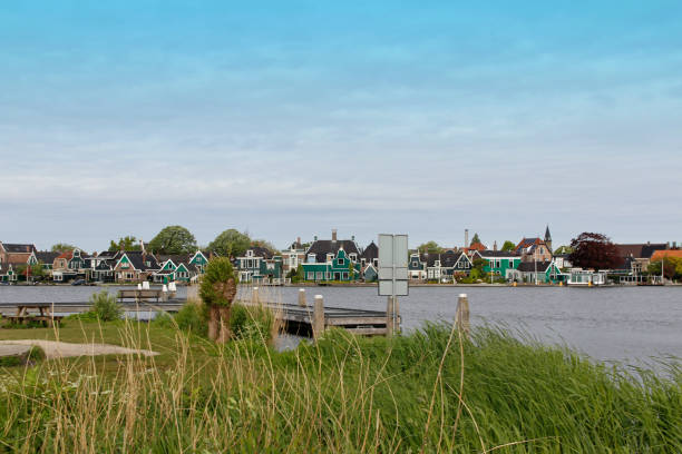 view of traditional dutch houses along the canal in spring - zaanse schans bridge house water imagens e fotografias de stock