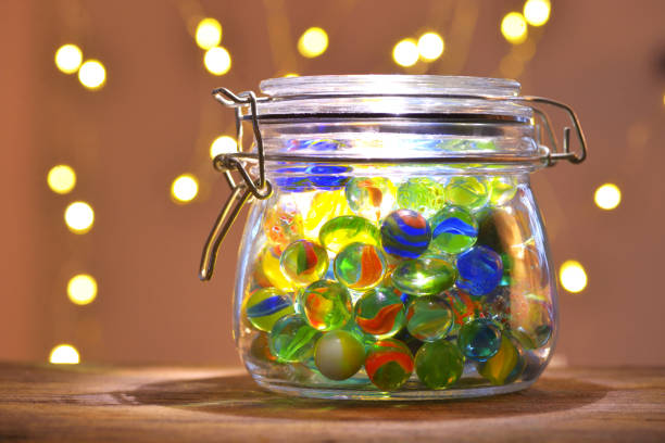Jar of Marbles and Christmas festive lights stock photo