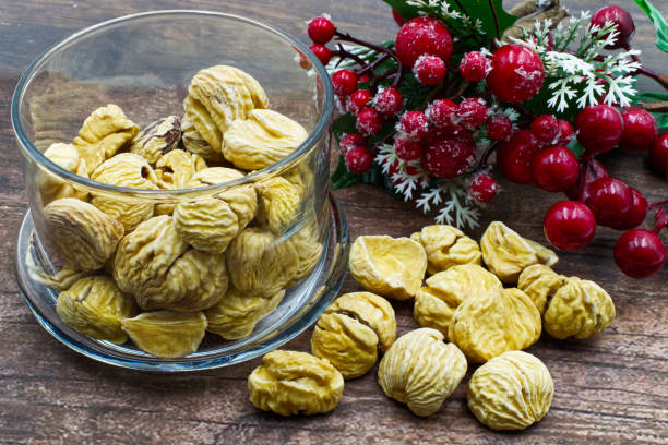 castagne secche su tavola di legno con decorazione natalizia - chestnut sweet food yellow group of objects foto e immagini stock