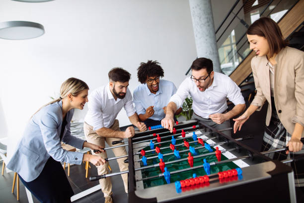 istock Happy young office workers playing table football 1193492992