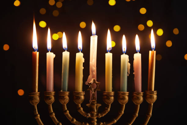 istock burning candles in menorah on black background with bokeh lights on Hanukkah 1193494521