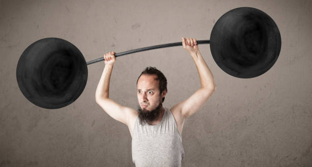 istock Funny skinny guy lifting weights 1193496649