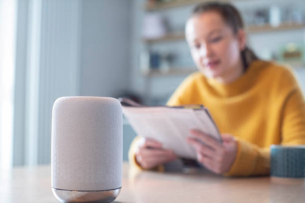Woman Reading Magazine At Home Asking Digital Assistant Question