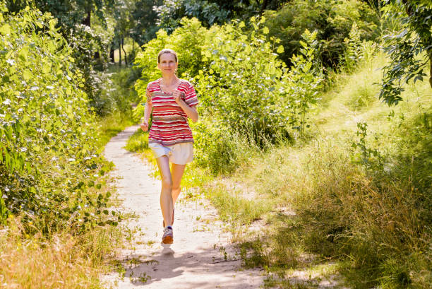 istock Senior Woman Running in the Forest 1193498264