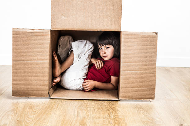 istock cool child hunched in cardboard box hiding in small house 1193499000