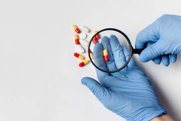 istock Concept - pharmaceutical testing, drug testing, magnifying glass, pills on a white background. Anti-Doping Control. 1193499827