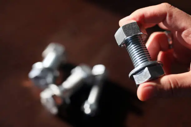 Photo of View of the bolt, nuts and washer. A fastener (US English) or fastening (UK English) is a hardware device that mechanically joins or affixes two or more objects together.