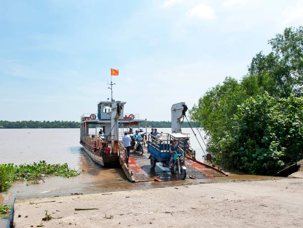 Sun Phu Ferry arrival, Mekong Delta, South Vietnam Sun Phu Ferry, Mekong River, South Vietnam. Water craft traffic such as barges, houseboats, passenger craft, industrial freighters and small ferries and personal boats travel the green rippled waters of the channels and routes of the mighty Mekong River as it flows to the Mekong Delta, South Vietnam small houseboats stock pictures, royalty-free photos & images