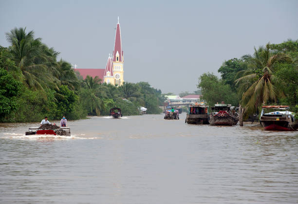 Mekong community, Mekong River, S.Vietnam Cai Thia area, Mekong Delta, South Vietnam. Water craft traffic such as barges, houseboats, passenger craft, industrial freighters and small personal boats travel the green rippled waters of the channels and routes of the mighty Mekong River as it flows to the Mekong Delta, South Vietnam small houseboats stock pictures, royalty-free photos & images