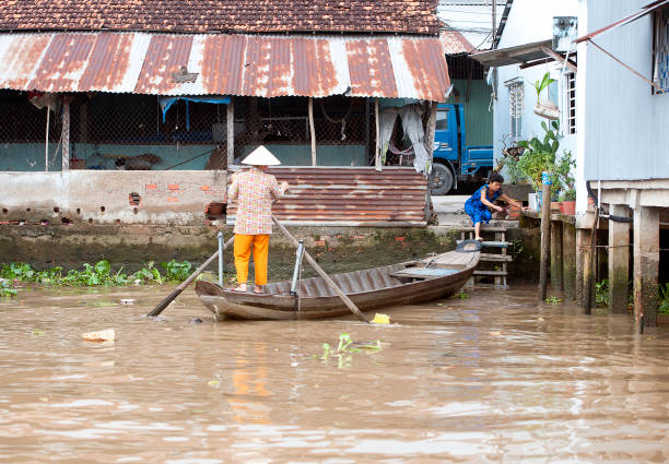 Water taxi arrival, Mekong River, South Vietnam Water taxi, Mekong River, South Vietnam. Water craft traffic such as barges, houseboats, passenger craft, industrial freighters and small personal boats travel the green rippled waters of the channels and routes of the mighty Mekong River as it flows to the Mekong Delta, South Vietnam small houseboats stock pictures, royalty-free photos & images