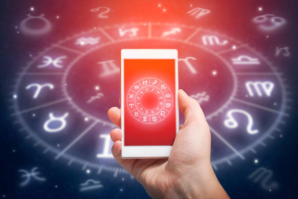 Astrology app Male hand holding smart phone device with astrology app, close up. Astrology and horoscope reading concept. capricorn photos stock pictures, royalty-free photos & images