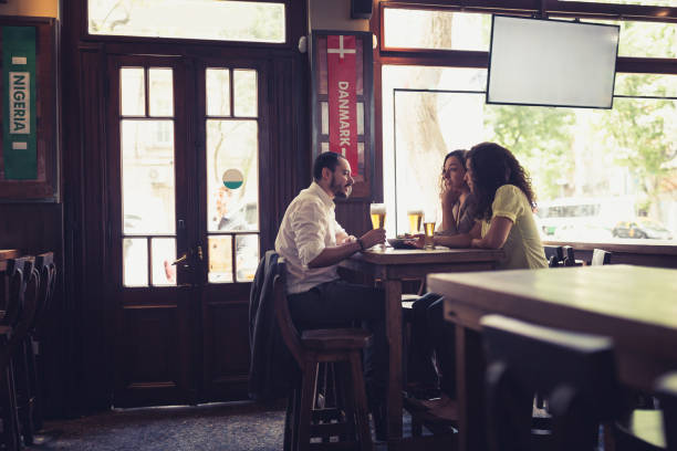 Friends gathering in pub after work, watching a soccer game. Buenos Aires, Argentina