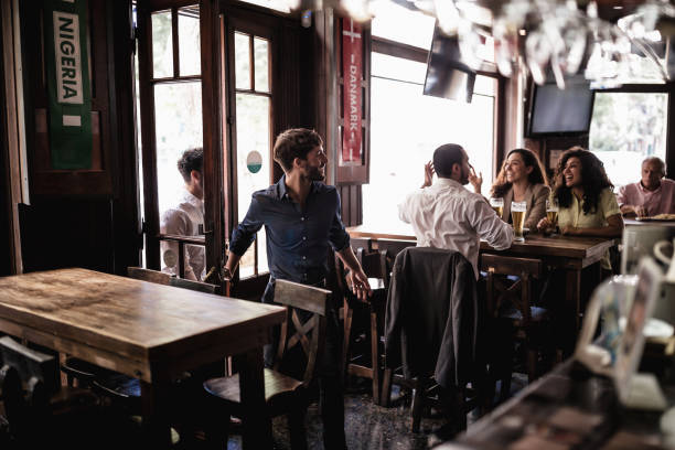 Friends gathering in pub, watching a soccer game