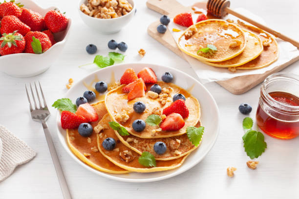 pancakes with blueberry strawberry honey and nuts for breakfast - norway maple imagens e fotografias de stock