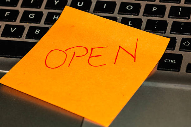 istock Writing on colorful sticky note Open. Text with Open on paper. Sticky note, post it on keyboard. 1193506591