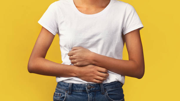 Cropped image of black woman suffering from stomachache Symptoms Of Food Poisoning. Close-up of african girl holding hands on stomach suffering from abdominal pain food poisoning stock pictures, royalty-free photos & images