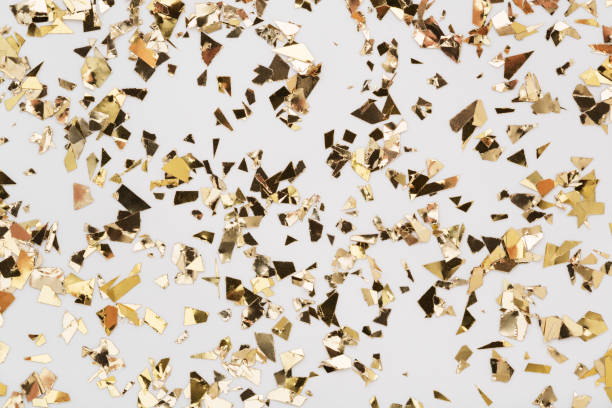 istock Gold leaf confetti on white background Festive party or holiday glitter backdrop. 1193508791