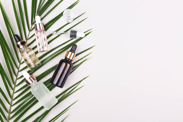 istock Various serum bottles on palm leaf on grey background. 1193508984