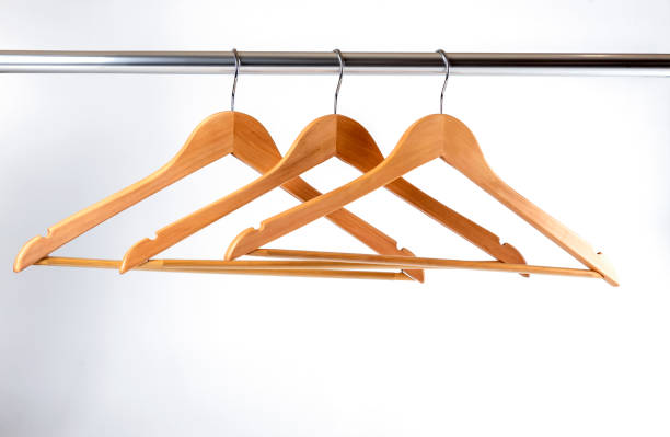 istock Three hangers hanging on a crossbar on a white wall 1193509098