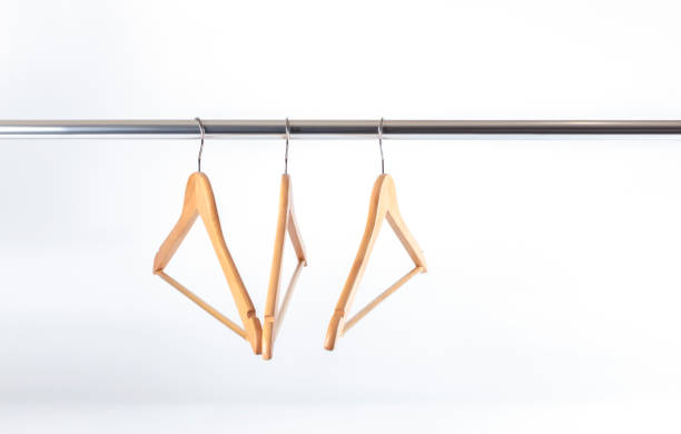 istock Three hangers hanging on a crossbar on a white wall 1193509100
