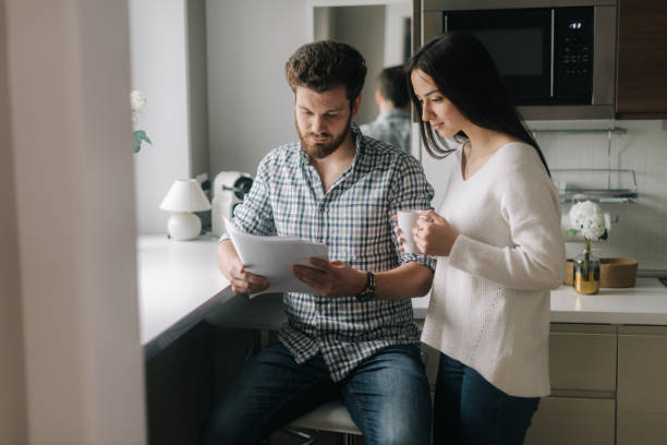 istock Young married couple studying mortgage documents together 1193509460
