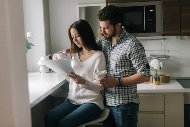 istock Lovely happy couple is reading documents. 1193509499
