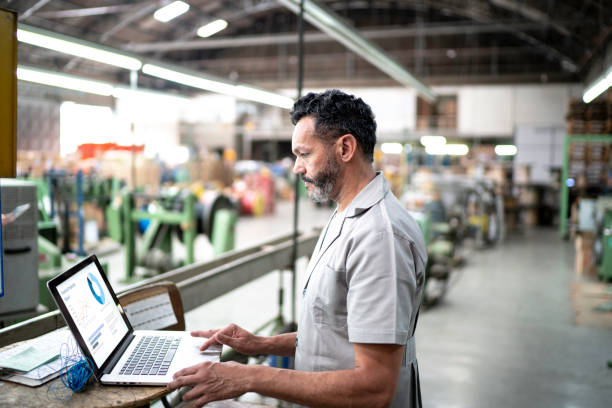 technician using laptop while working in a factory - plant stand imagens e fotografias de stock