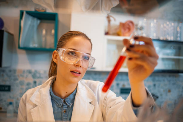 Scientist Working in The Laboratory Young woman in whitecoat studying new chemical substances in lab. Patient personal health care taken by a specialist biochemist research facility. One women in the lab cerebrospinal fluid photos stock pictures, royalty-free photos & images