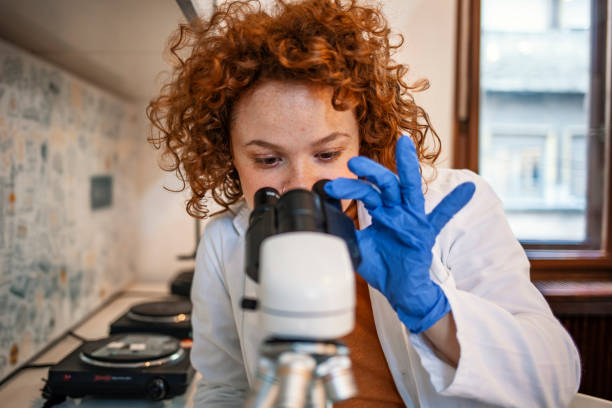 Young Scientist Working With The Microscope Scientist researcher using microscope in laboratory. Medical healthcare technology and pharmaceutical research and development concept. Young Scientist Working With The Microscope laboratory chemist scientist medical research stock pictures, royalty-free photos & images