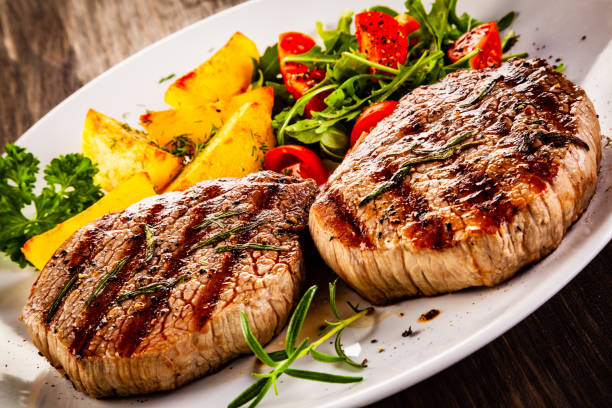 istock Beef steak, fried potatoes and vegetables on white background 1193514948