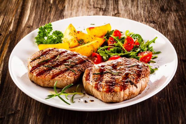 istock Beef steak, fried potatoes and vegetables on white background 1193514986