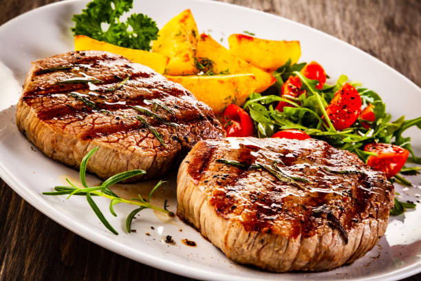 istock Beef steak, fried potatoes and vegetables on white background 1193515019