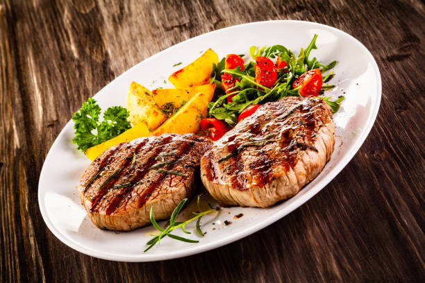 istock Beef steak, fried potatoes and vegetables on white background 1193515071