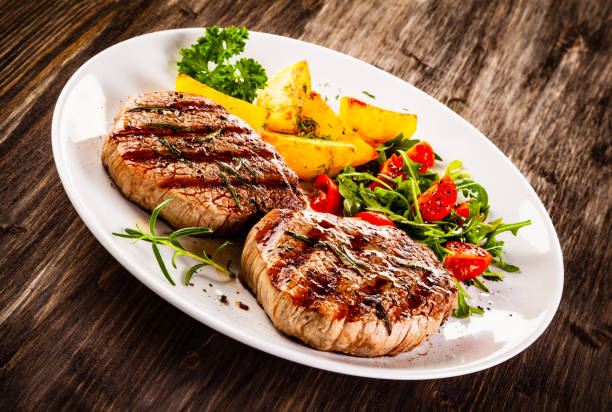 istock Beef steak, fried potatoes and vegetables on white background 1193515167