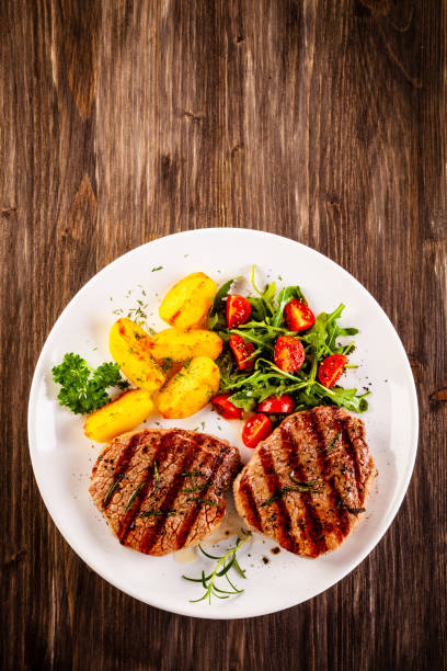 istock Beef steak, fried potatoes and vegetables on white background 1193515238