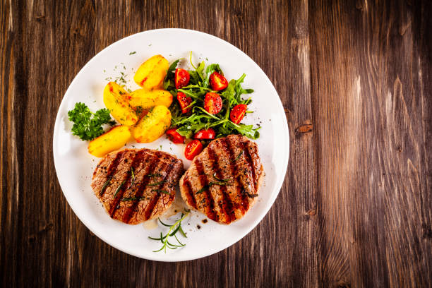istock Beef steak, fried potatoes and vegetables on white background 1193515259