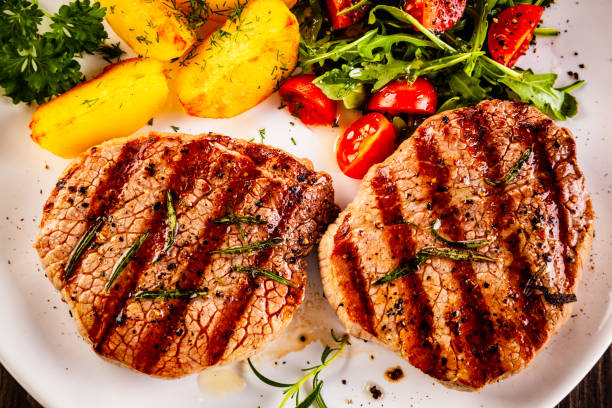 istock Beef steak, fried potatoes and vegetables on white background 1193515302