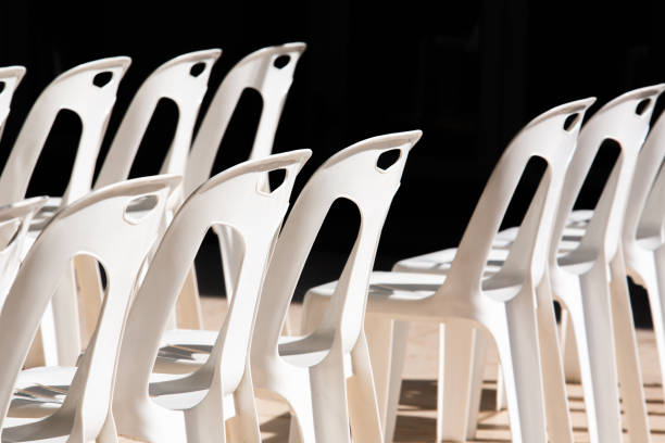 istock row of white plastic chairs in the sun on a black background.shallow focus effect. 1193517510