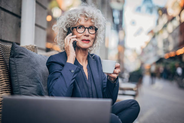 istock Lady talking on mobile outdoors in cafe 1193517941