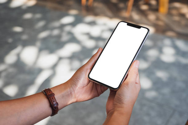 istock Mockup image of hands holding black mobile phone with blank desktop screen 1193520301