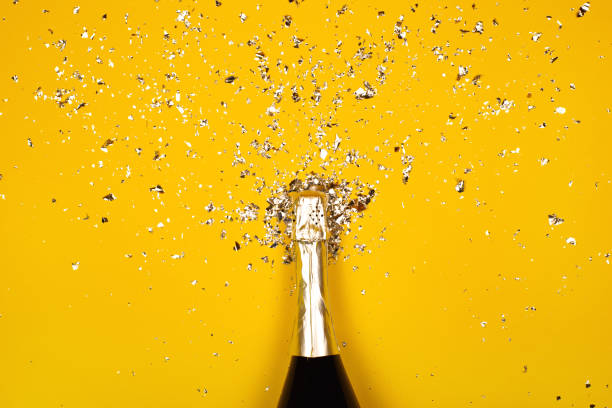 Bottle of champagne with confetti Bottle of champagne with splash of confetti. Flat lay style. top honor stock pictures, royalty-free photos & images